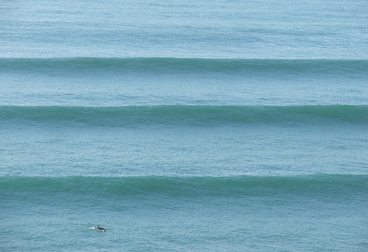 Surfer paddling into a powerful blue wave on the KwaZulu-Natal coast, South Africa